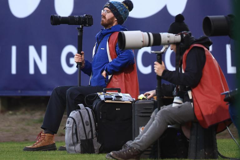 Shot of James Thomson taking photographs at a football match