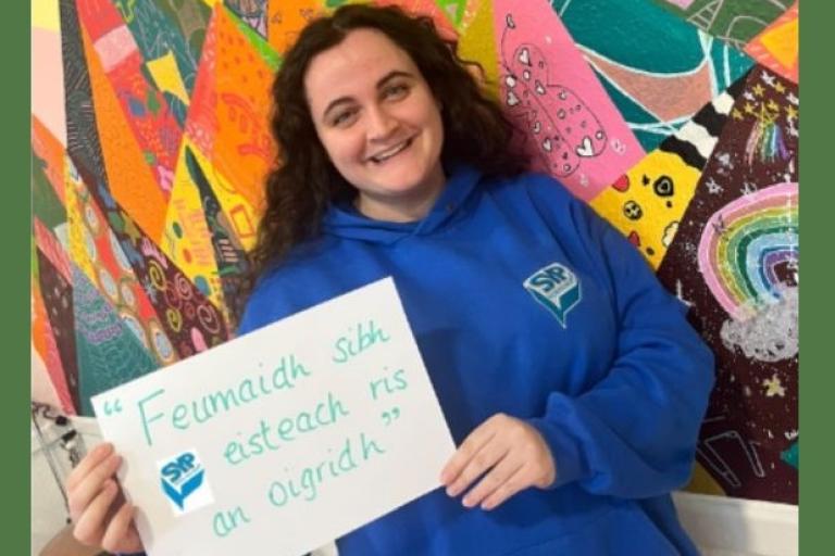 A member of SYP holding a sign with Gaelic text