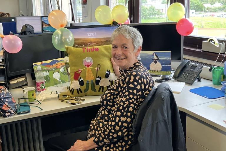 Colleague at her desk with balloons